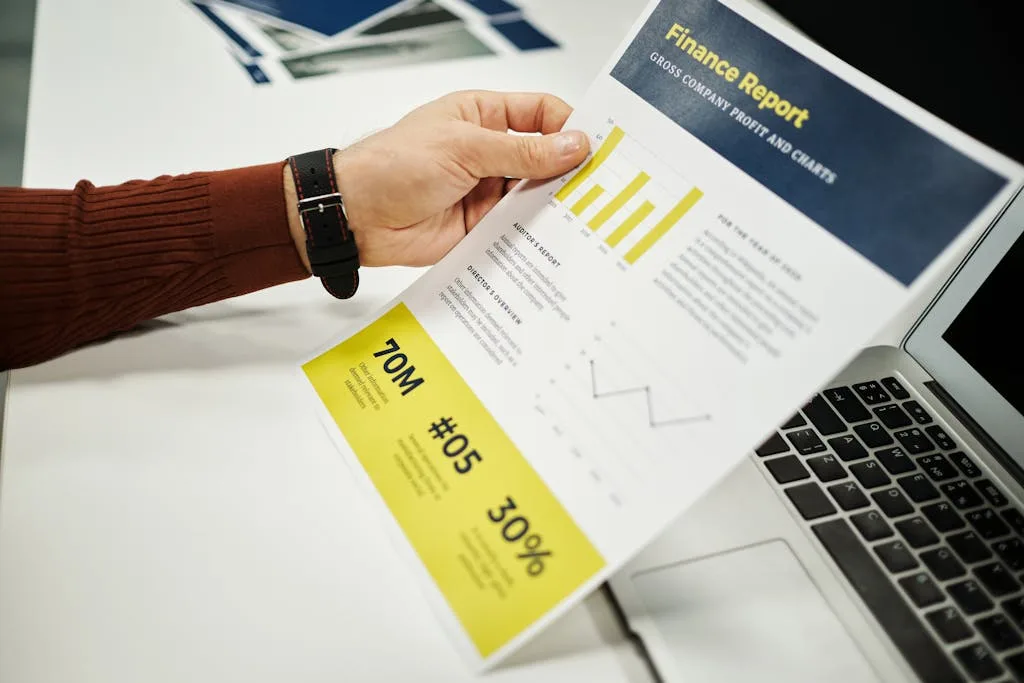 Person analyzing finance report with graphs at desk, ideal for business concepts.